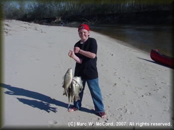 Austin can barely hold up the stringer of white bass he caught in an hour